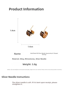 Macro view of asymmetric C-shaped gold-plated earrings with black enamel and silver needles
