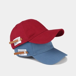 Classic cotton baseball caps in red and blue with vintage leather labels and curved brims