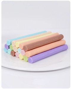 Detailed macro view of colorful sealing wax sticks with spiral texture in a white ceramic dish
