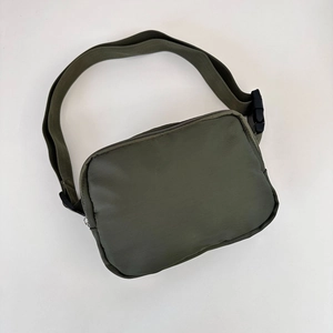 Detailed view of the olive green nylon crossbody waist bag with adjustable buckle strap