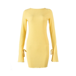 Gros plan détaillé d'une robe mini jaune en maille avec manches évasées et cordon