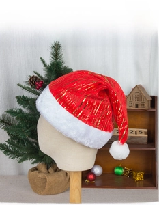 Détail du bonnet de Noël rouge avec rayures dorées et bordure en peluche blanche