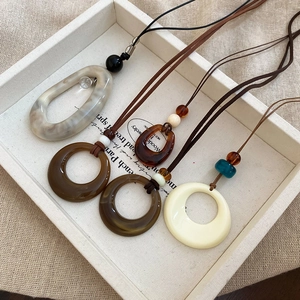 Gros plan de pendentifs géométriques en résine avec textures marbre et ambre