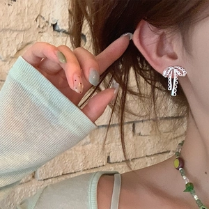 Boucles d'oreilles nœud en argent avec dentelle métallique sur un mannequin