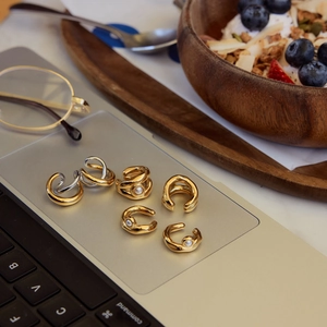 Set di orecchini a clip con perle oro e argento su un laptop in un ambiente accogliente