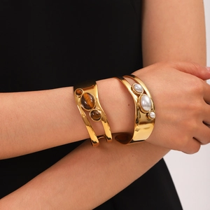 Gold stainless steel open bangle with tiger eye stone and white pearl detail