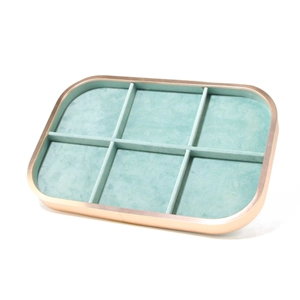 Macro detail of six-compartment jewelry display tray in rose gold with mint velvet
