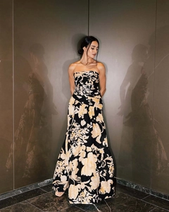 Detail of elegant strapless floral maxi dress with large cream flowers on black fabric