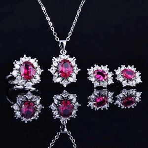 Close-up of luxury red gemstone jewelry set featuring a necklace, ring and earrings