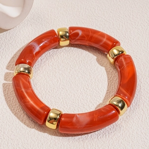 Detail of red marble texture acrylic bamboo tubes and polished gold spacers bracelet