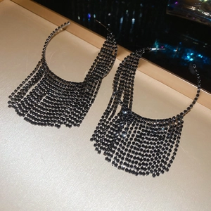 Detailed close-up of long black rhinestone tassel earrings with sparkling metallic finish