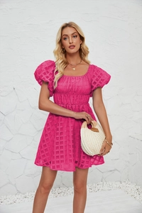 Détail d'une robe rose fushia à épaules dénudées avec manches bouffantes et tissu gaufré
