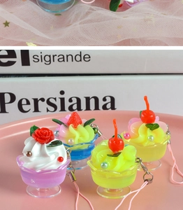 Detailed view of mini cream sundae pendants in pastel cups on a pink tray
