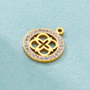 Close-up of golden clover pendant with hollow design and sparkling rhinestone border