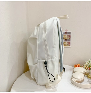 Side view of a large capacity white backpack showing side pocket and adjustable drawstring