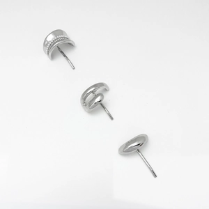 Detail view of silver metal studs including pearl arc, knot, and pebble designs