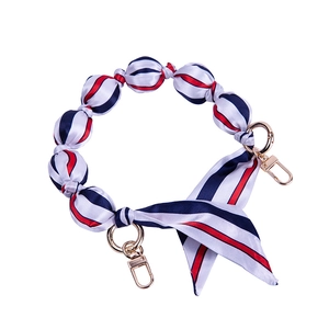 Detail of red white and blue striped fabric bag handle with gold spring ring clasps