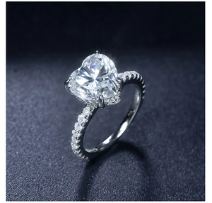 Macro shot of 3.5 carat heart-shaped moissanite ring with pavé-set diamond band detail