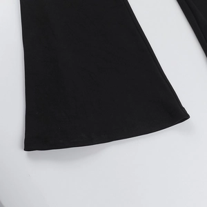 Vue détaillée du bas évasé de la combinaison noire avec couture à double aiguille