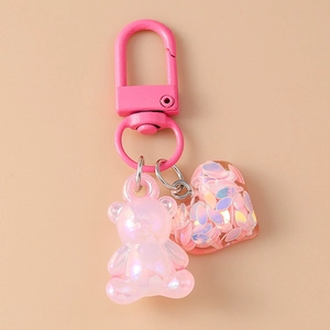 Detail of pink bear and heart keychain featuring glitter resin and pearl finish charm