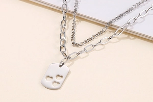 Macro detail of silver double-layer necklace with hollow heart rectangular pendant