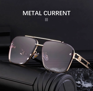 Detail of square pilot sunglasses with gold metal frame and gradient lenses on black pedestal