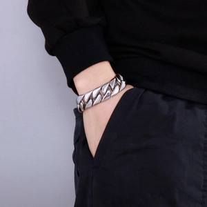 Close-up of thick silver Cuban link bracelet in titanium steel worn on a male wrist