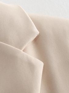 Detailed macro view of high-quality twill fabric on light beige blazer lapel