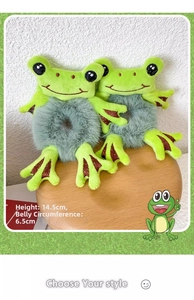 Detail view of plush frog hair scrunchies showing green soft fabric and cute embroidery