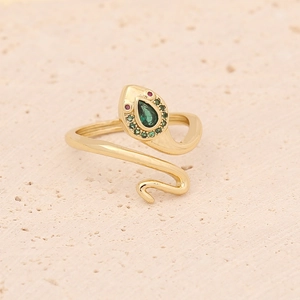 Macro shot of gold snake ring with green teardrop stone and red crystal eyes