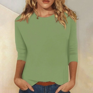 Detalle de cuello redondo y mangas 3/4 en una camiseta entallada verde hierba