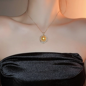 Gros plan du collier pendentif fleur en perle dorée avec incrustation de zircon brillant