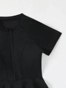 Détail de maillot de bain noir à manches courtes avec col montant et fermeture éclair