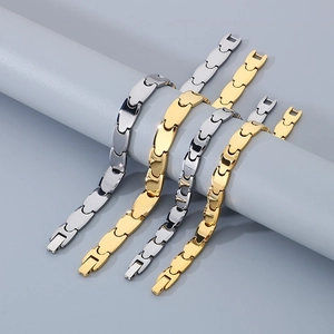 Detail of interlocking geometric link bracelets in gold and silver with fold-over clasp