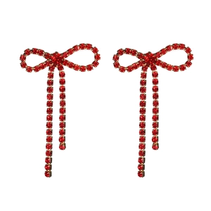 Detailed close-up of red rhinestone bow earrings with sparkling crystal tassels