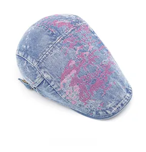 Vista dall'alto della coppola in denim blu con stampe graffiti rosa e fibbia in metallo