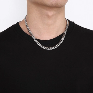 Close-up of chunky silver Cuban link chain necklace on model neck in bright studio light