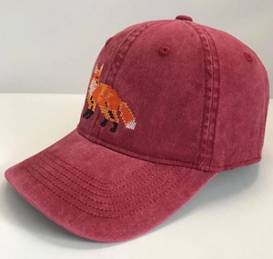 Detail of pixel art fox embroidery on a burgundy washed canvas baseball cap