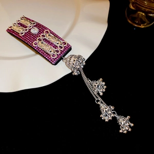 Close-up of vintage purple rhinestone headband with detailed silver hollow bell charms