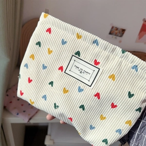 Cream corduroy makeup bag with colorful heart embroidery and Time to Party label