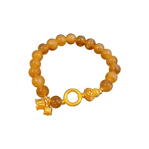 Bracciale di citrino con ciondoli in oro e perle in filigrana su sfondo bianco