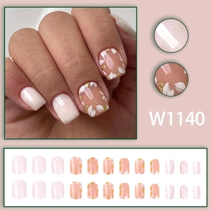Short press-on nails with pink floral petals and gold foil accents in square oval shape