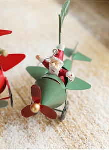 Detailed close-up of retro metal Santa Claus flying a plane Christmas ornament decoration
