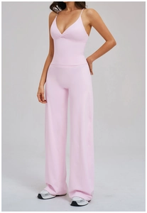 Détail d'un ensemble de yoga rose clair avec débardeur à bretelles en V et pantalon large