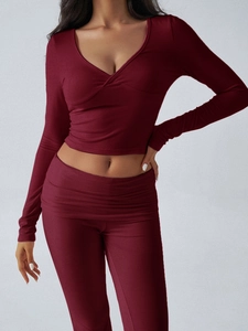 Detail of burgundy two-piece knit set featuring V-neck cropped top and high waist pants