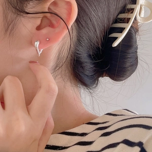 Close-up of minimalist 925 sterling silver irregular geometric hoop earrings on model