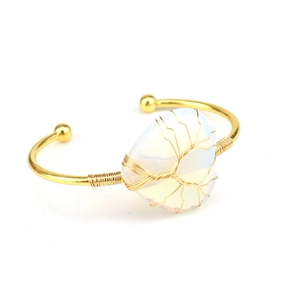 Detailansicht des handgefertigten Lebensbaum-Opals am goldenen offenen Manschettenarmband