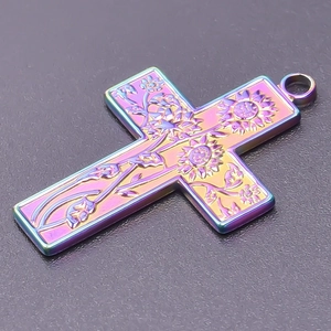 Macro detail of rainbow stainless steel cross pendant with sunflower relief and floral pattern