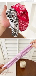 Elastic paisley print headbands in red, black and purple shown for stretch and texture