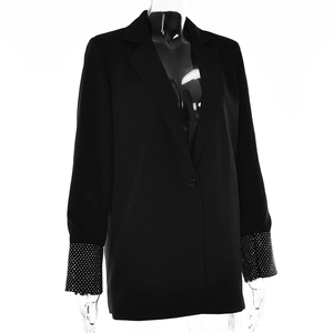 Dettaglio della manica del blazer nero con strass densi e dettagli sui bottoni